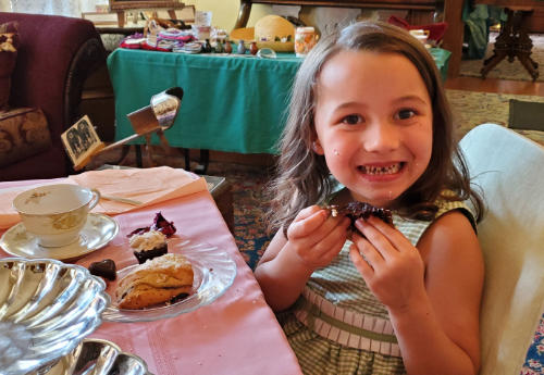 child enjoying cupcake at tea